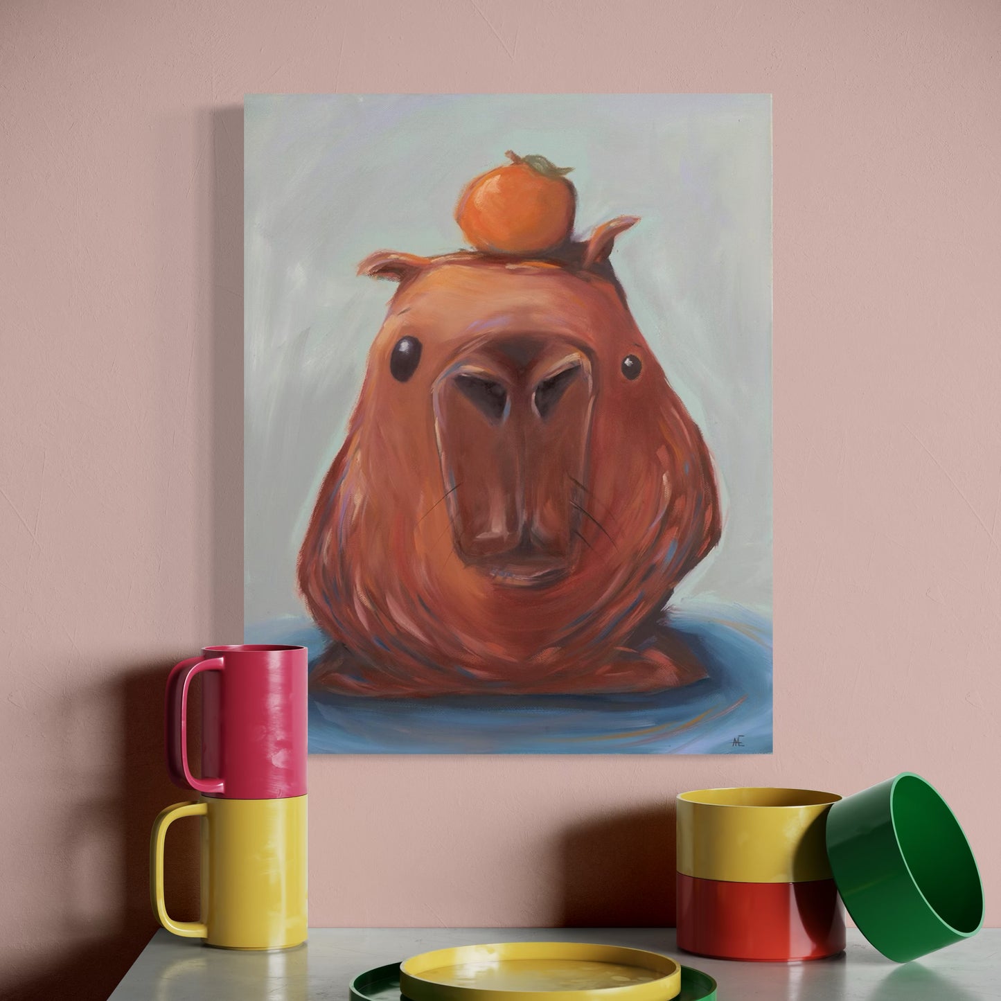 Painting of a capybara's head with an orange on its head, displayed on a wall above colorful mugs and a plate.