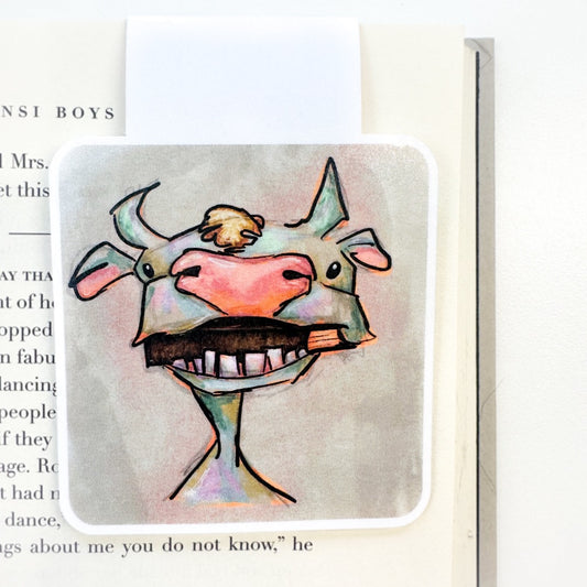 image of a cow munching on a book on a magnetic bookmark