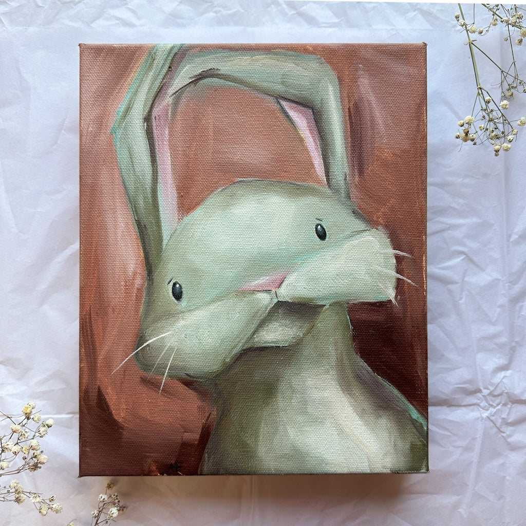 an oll painting of a light green bunny with an abstract rust red background. 