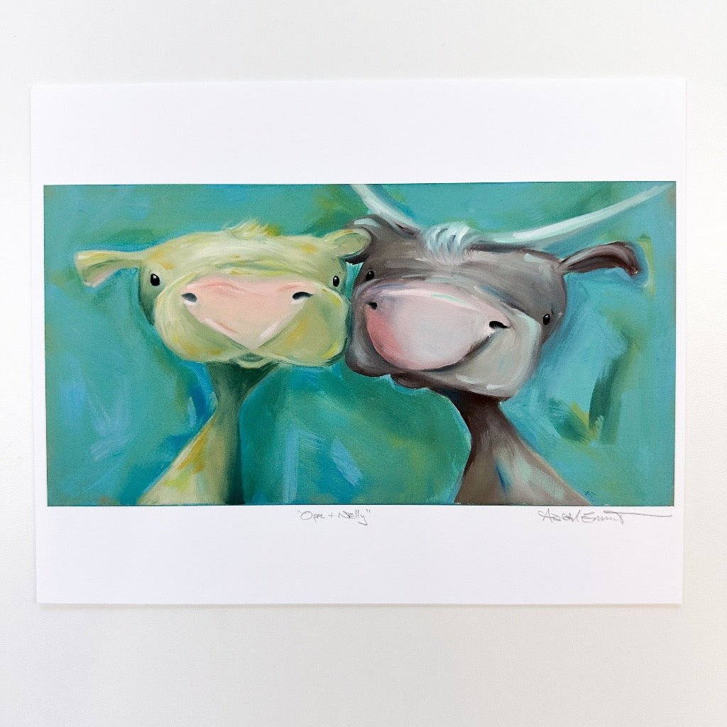 two cute cows side by side. One is lighter colored with yellow accents and the other has horns and is a brown tone.