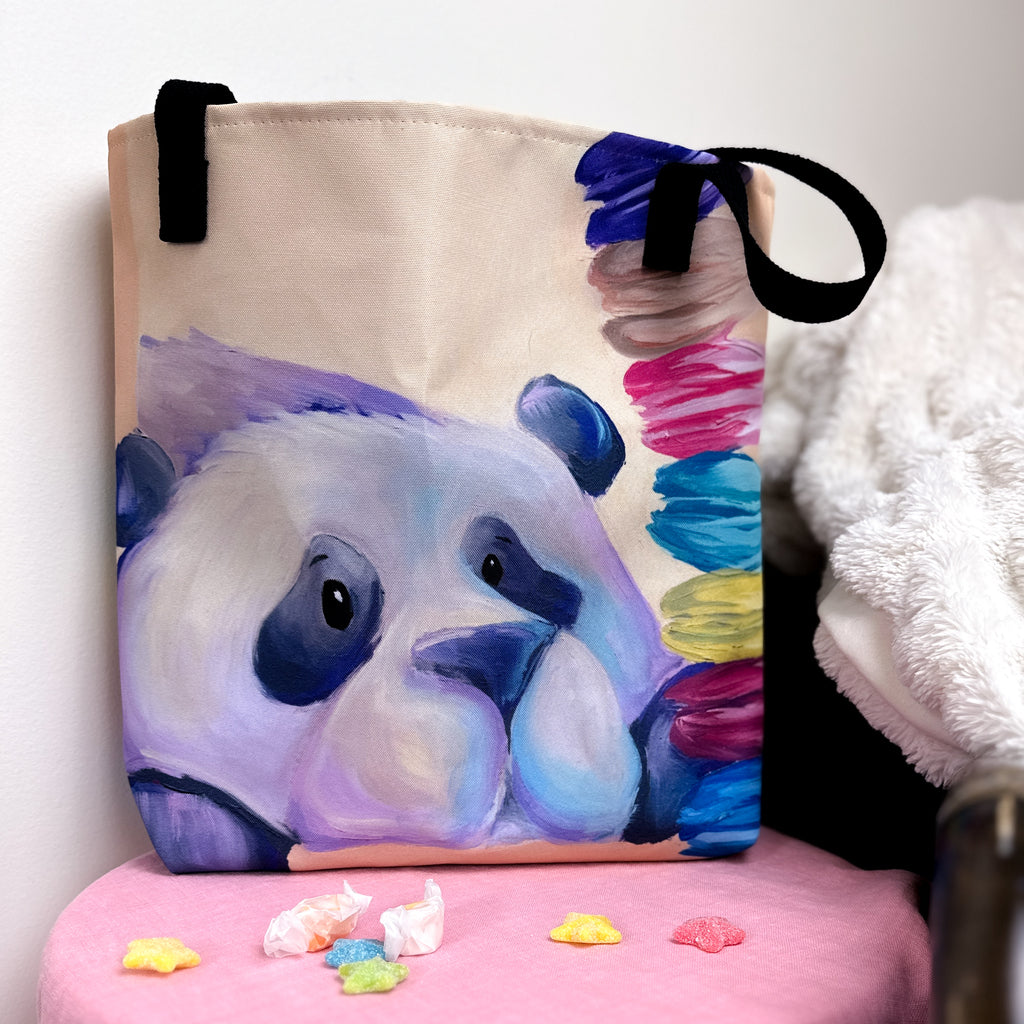 Close up image of tote bag with purple panda staring at the stack of macarons.