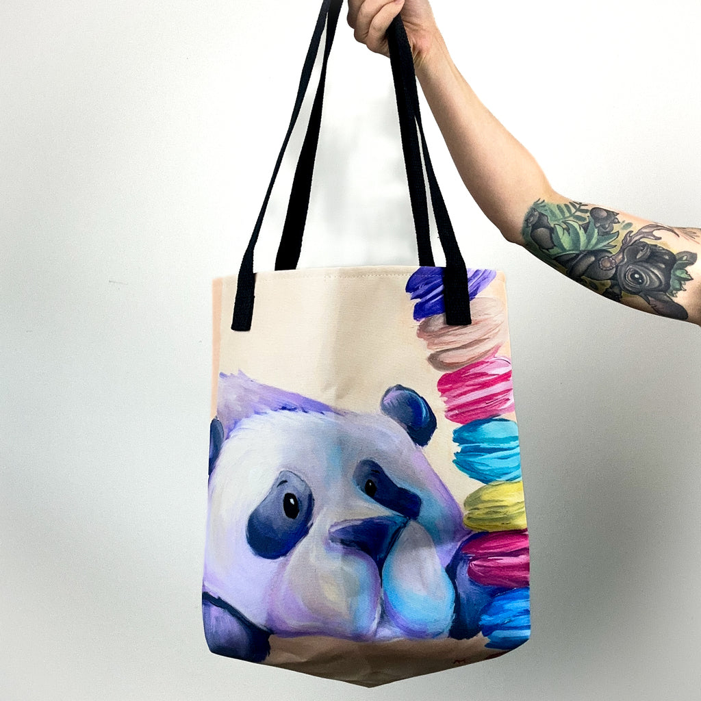 Close up image of tote bag with purple panda staring at the stack of macarons.