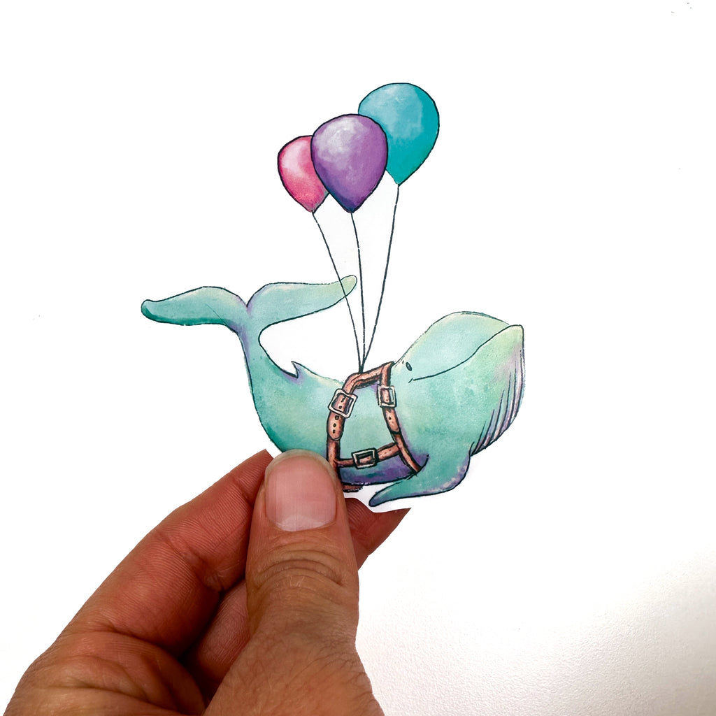An illustrated sticker of a blue whale with a smile and wearing a harness carried by 3 balloons, pink, purple and blue