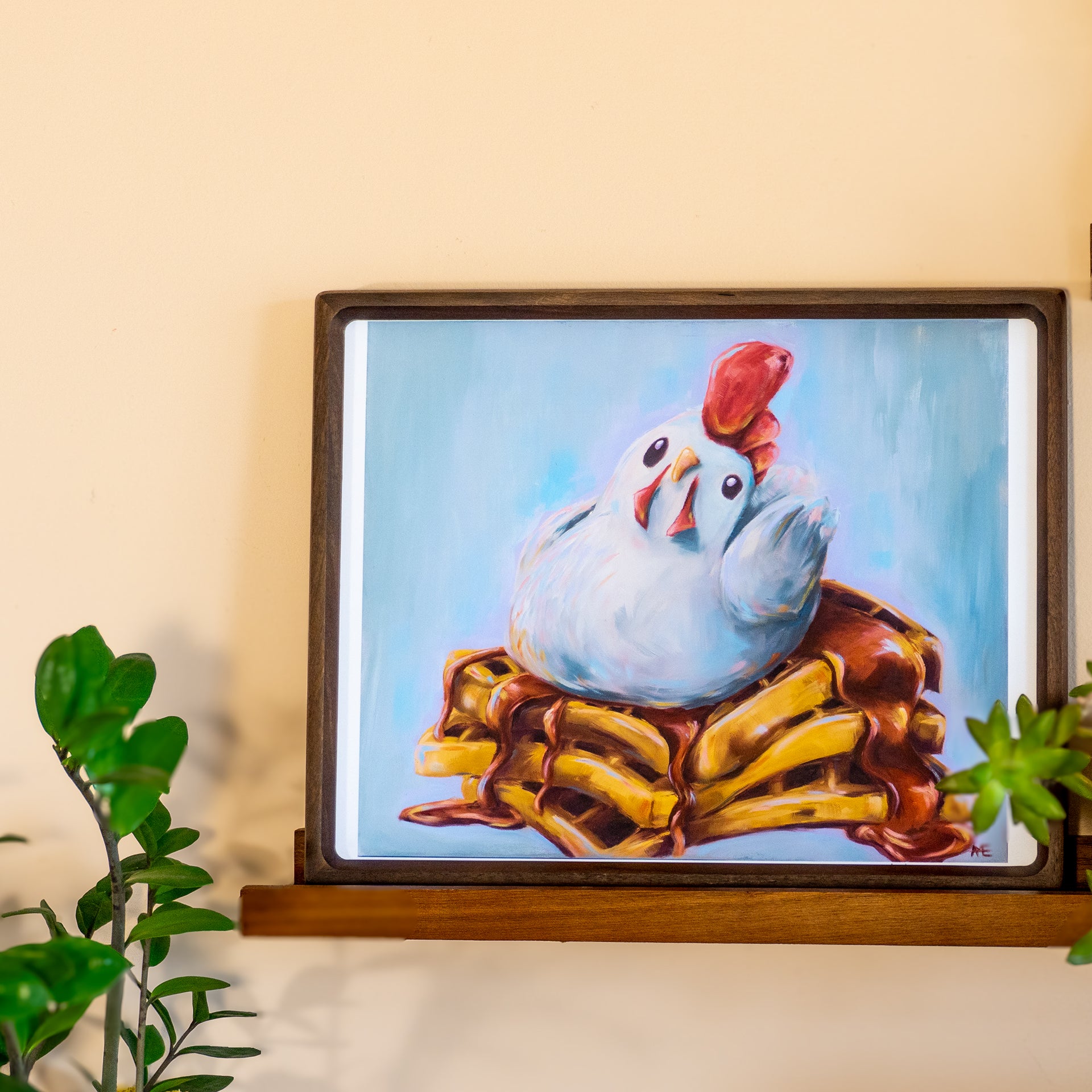 FINE ART PRINT OF AN OIL PAINTING OF A WHIMSICAL CHICKEN ON A STACK OF WAFFLES WITH SYRUP. THIS IS A FRAMED EXAMPLE OF THE 11X14 SIZE 