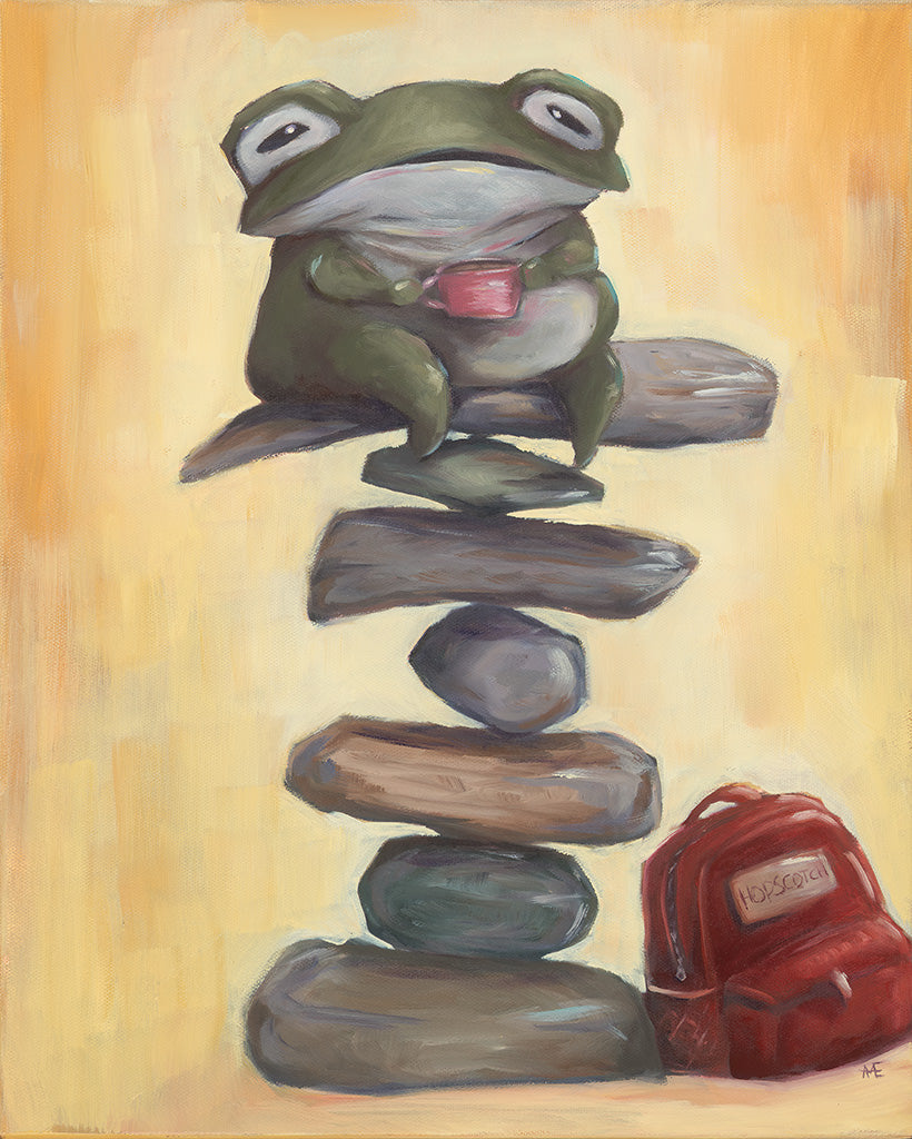 Frog sitting on stacked stones with a red backpack in the corner on a beige background