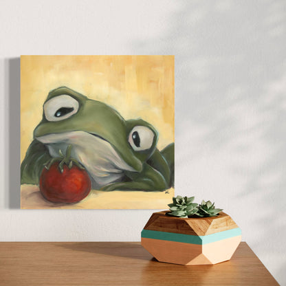 painting of a frog staring longingly at a cherry tomato hanging on a wall above a wooden surface with a geometric plant holder.