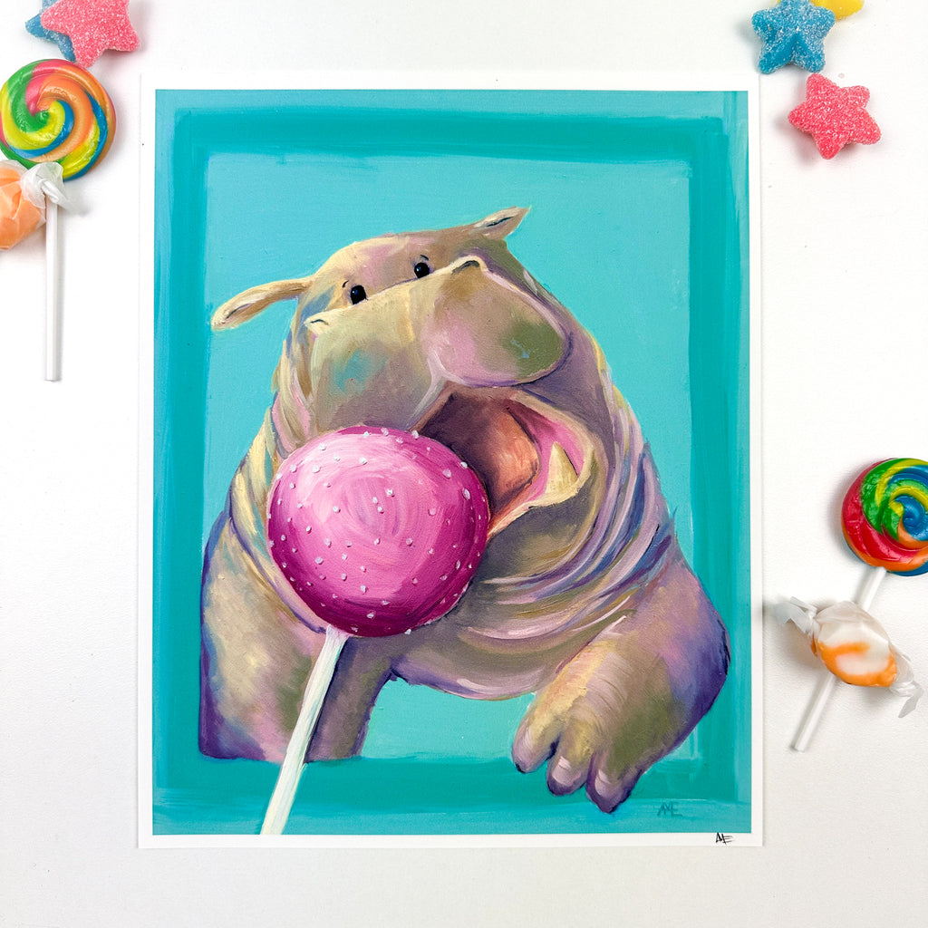 fine art print of cute kawaii style hippo busting out of a border and open mouth going after a pink cake pop stylized with candy around it.
