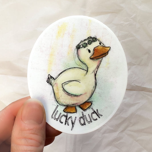 illustrated white duck with a shamrock crown, under it reads "lucky duck"
