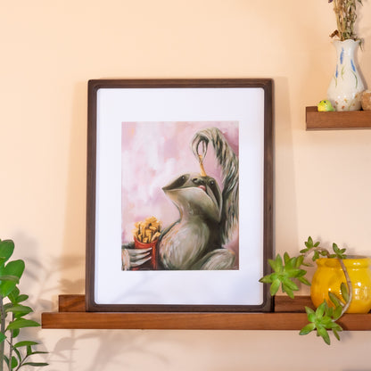 Framed  print of a sloth holding a French fry over his mouth. 