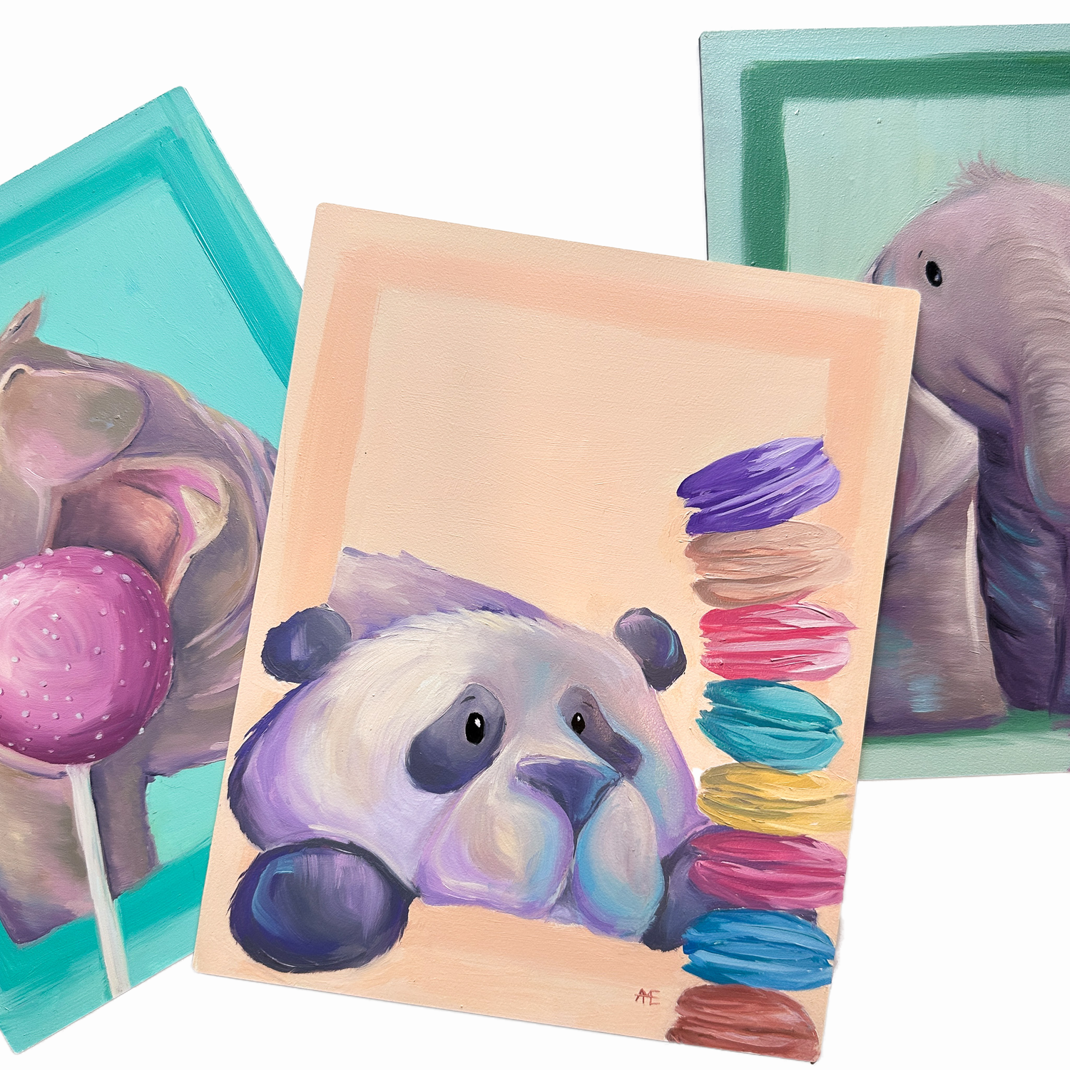 three paintings, a panda and macarons in the middle with peach background, an elephant to the right and partial hippo to the left