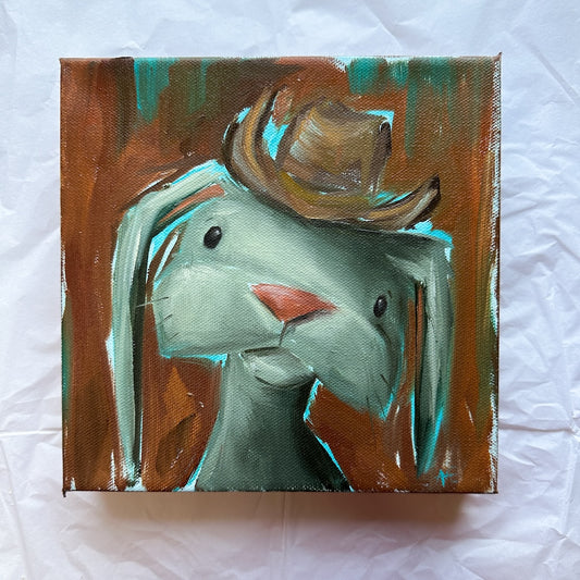 Oil painting of a  bunny wearing a cowboy hat with a rust orange and brown background and turquoise highlights. 