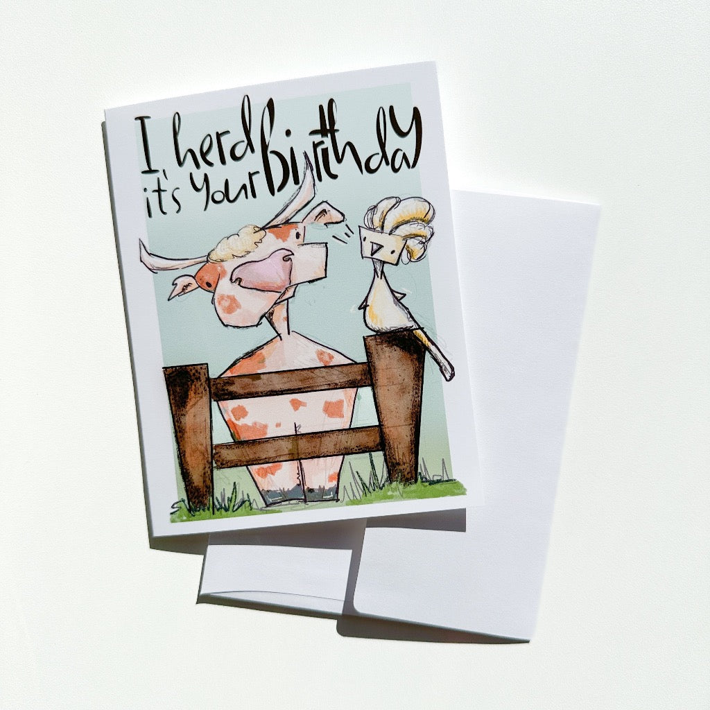 cow and cockatoo greeting card with white envelope showing behind it. 