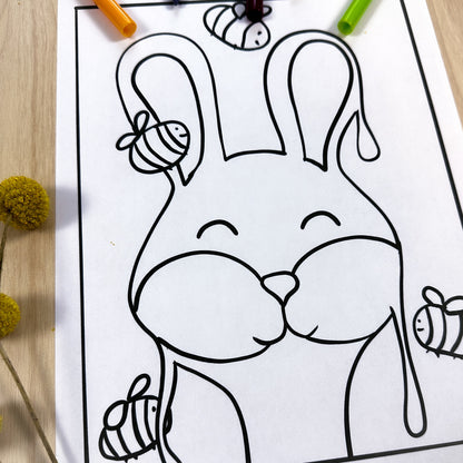 Coloring page of a bunny facing the front of the page with tall standing up ears. There are 4 bumble bees surrounding the honey. The honey has drips coming off of it because it's a Honey Bunny. 