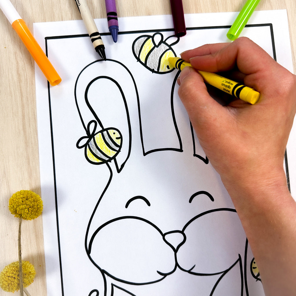 Partially colored coloring page of a bunny facing the front of the page with tall standing up ears. There are 4 bumble bees surrounding the honey. The honey has drips coming off of it because it's a Honey Bunny. 