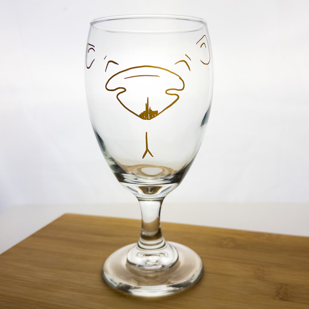 iced tea glass with yellow outline of a bear face on the front. 